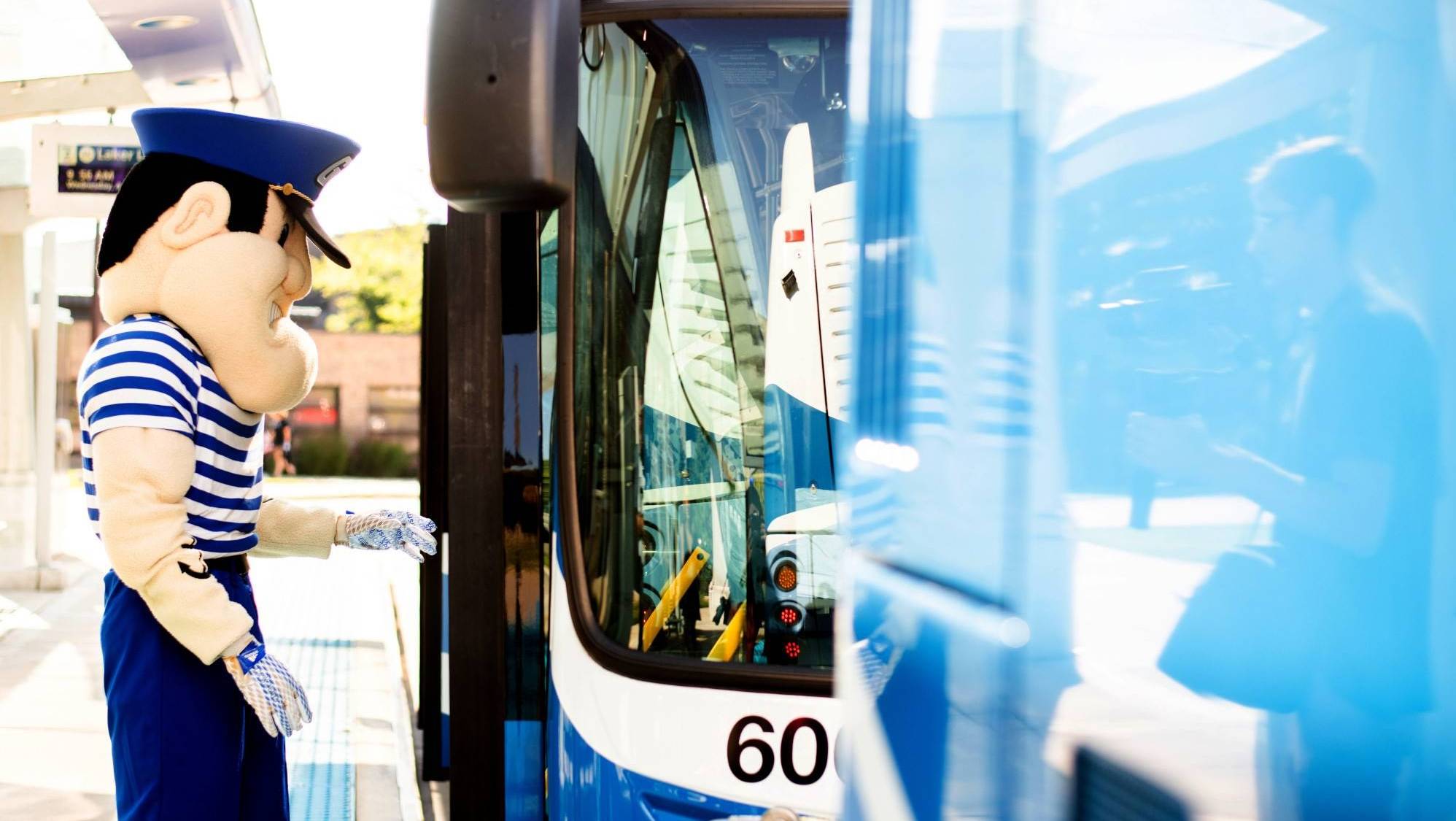 Louie boards a bus on campus